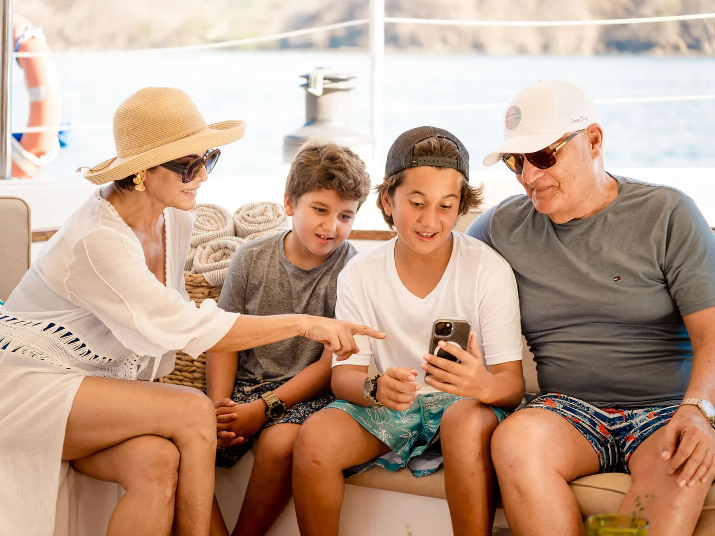 A group of guests seated together on the shaded deck of an Ocean Club catamaran, Costa Rica