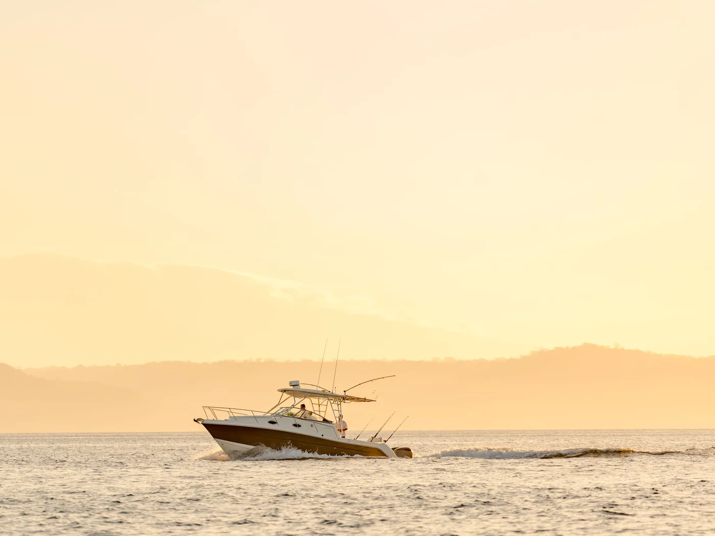 An Ocean Club sportfishing boat at anchor in golden evening light on Costa Rica's Pacific coast