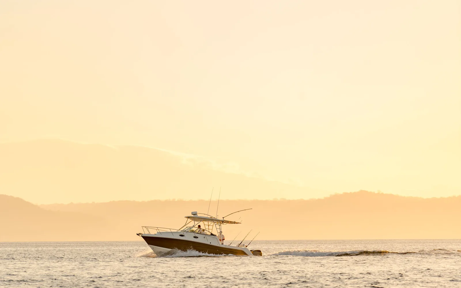 Disparate, an Ocean Club sportfishing boat, at anchor in golden evening light on Costa Rica's Pacific coast