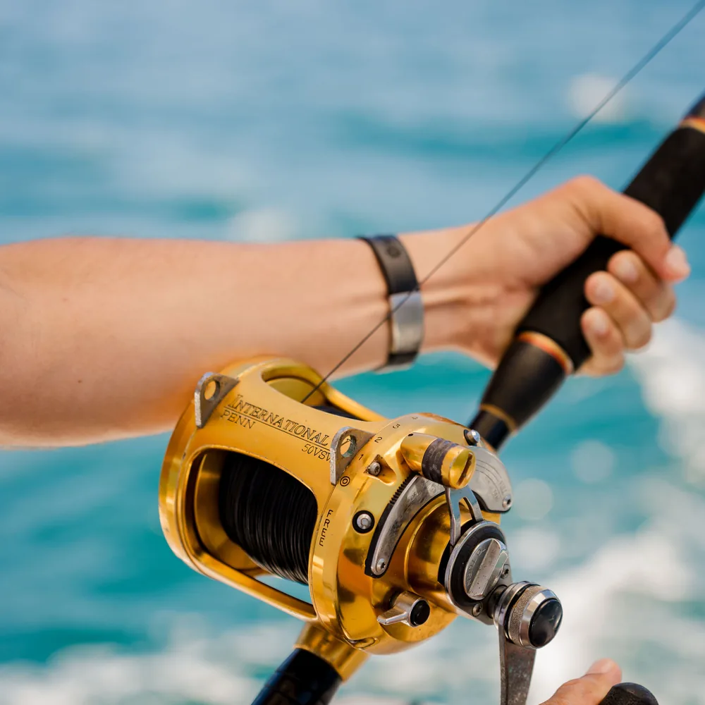 Close-up of a fishing reel and rod aboard an Ocean Club charter boat