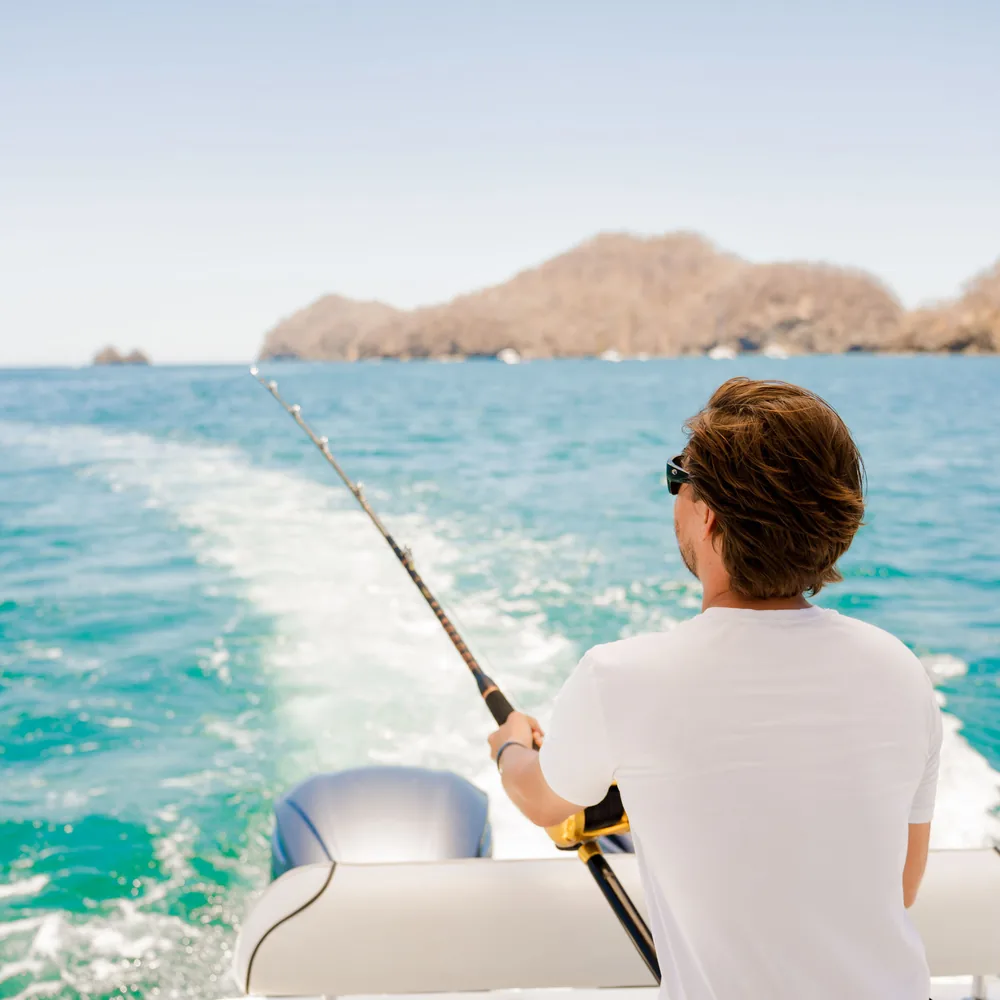 A young guest fishing from the stern of an Ocean Club charter boat, Costa Rica