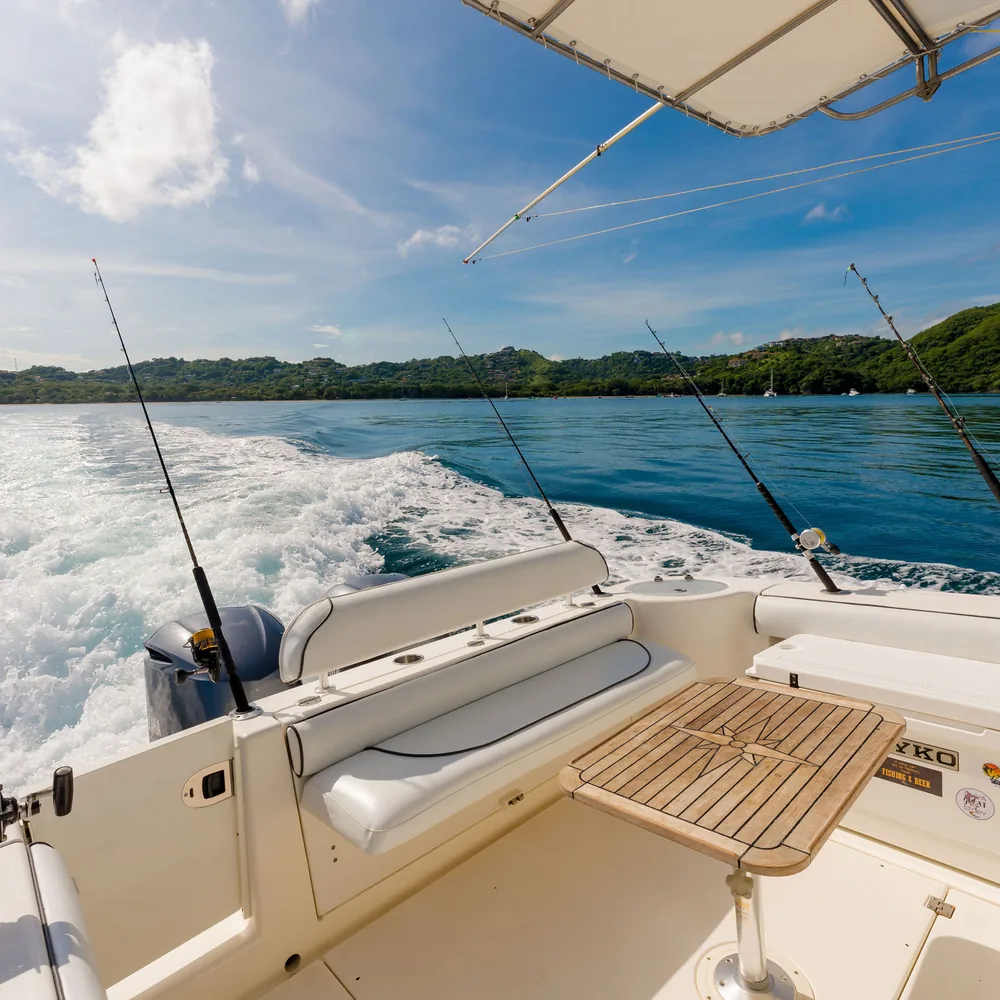 Fishing rods racked in the rod holders of an Ocean Club charter boat under way