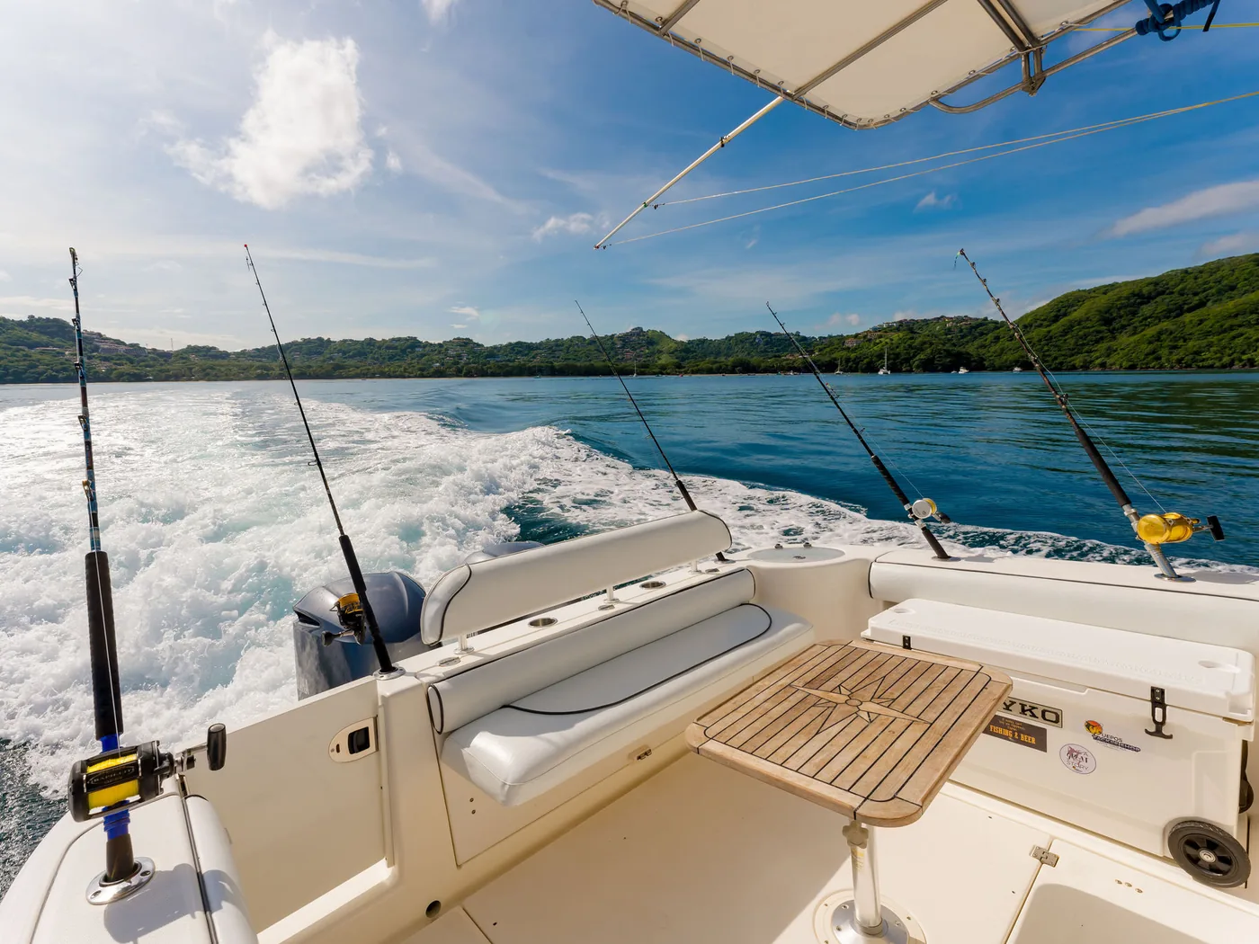 Fishing rods set in the rod holders of an Ocean Club charter boat under way off Costa Rica