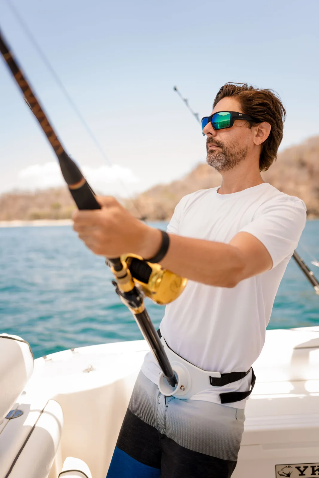 An angler fighting a fish aboard Disparate off the Guanacaste coast