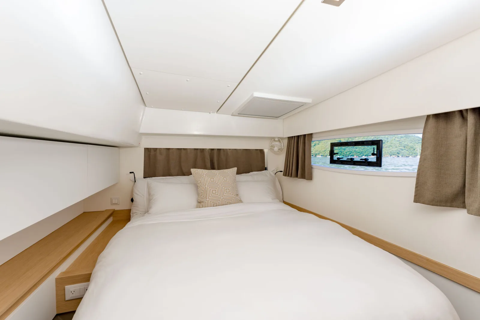A guest cabin aboard Endeavour, with a double berth and pale wood joinery