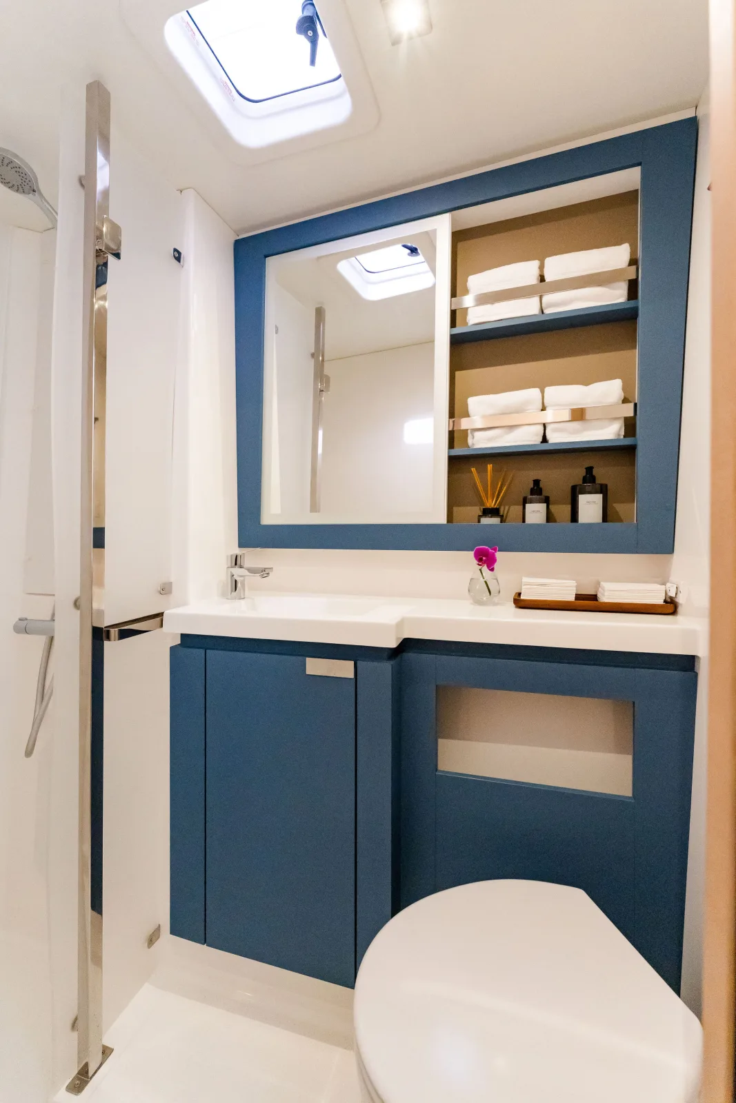 An en-suite head aboard Endeavour, with vanity, mirror and blue cabinetry