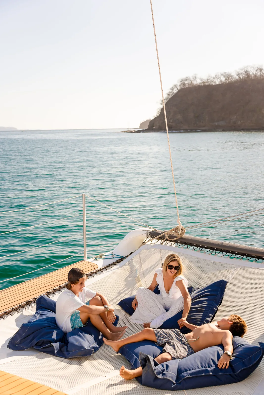 A guest relaxing on the foredeck beanbags aboard Lohe Lani