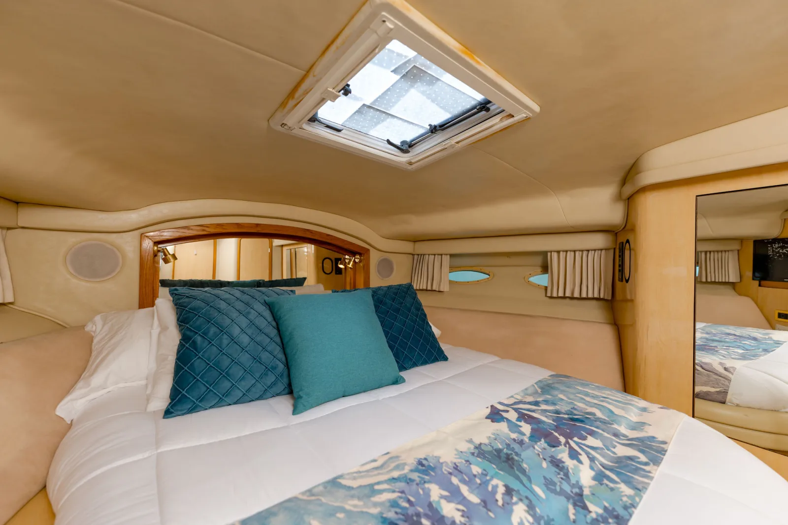 The air-conditioned cabin aboard Sea Ya, with a double berth and teal cushions