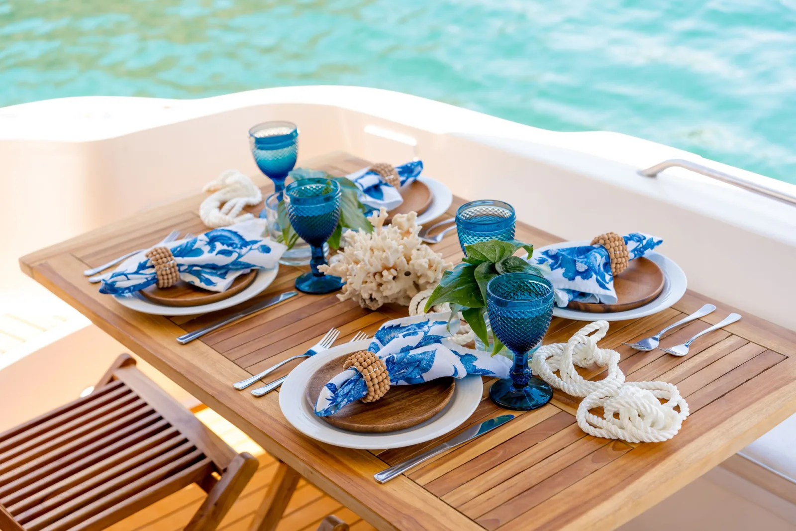 Sea Ya's teak aft-deck table laid for lunch with blue glassware