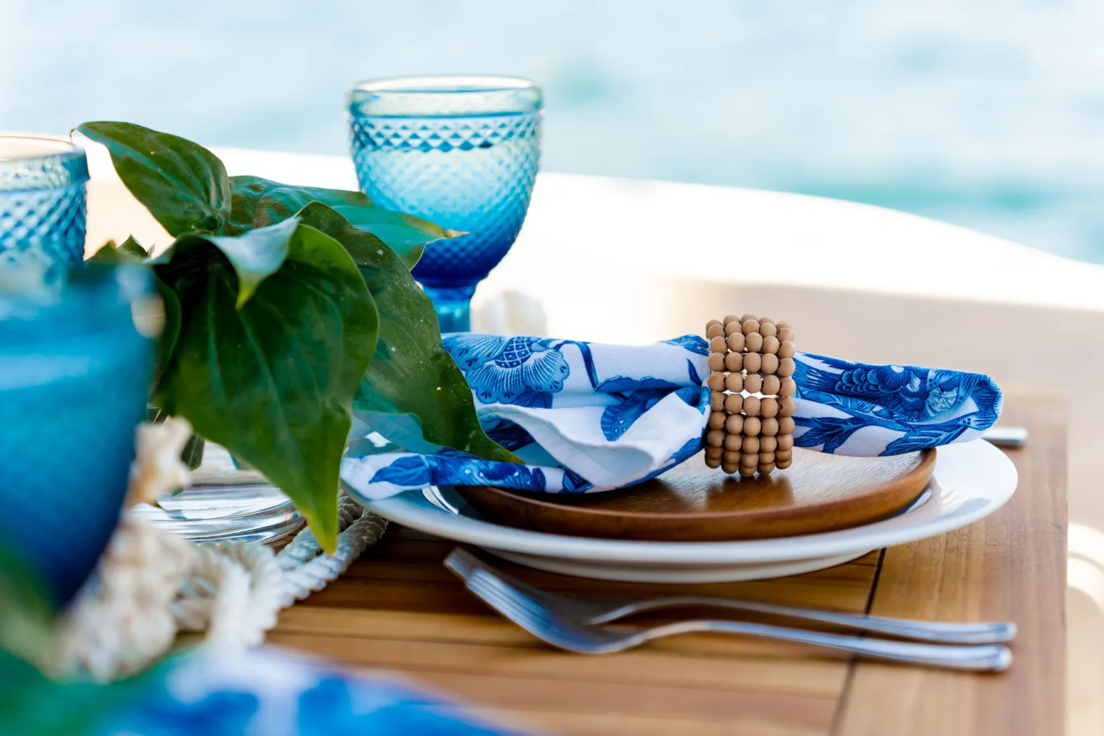 Blue glassware and printed linen on Sea Ya's aft-deck table
