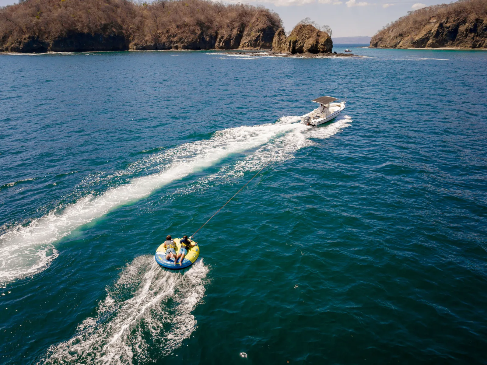 The Ocean Club tender towing a tube across flat water