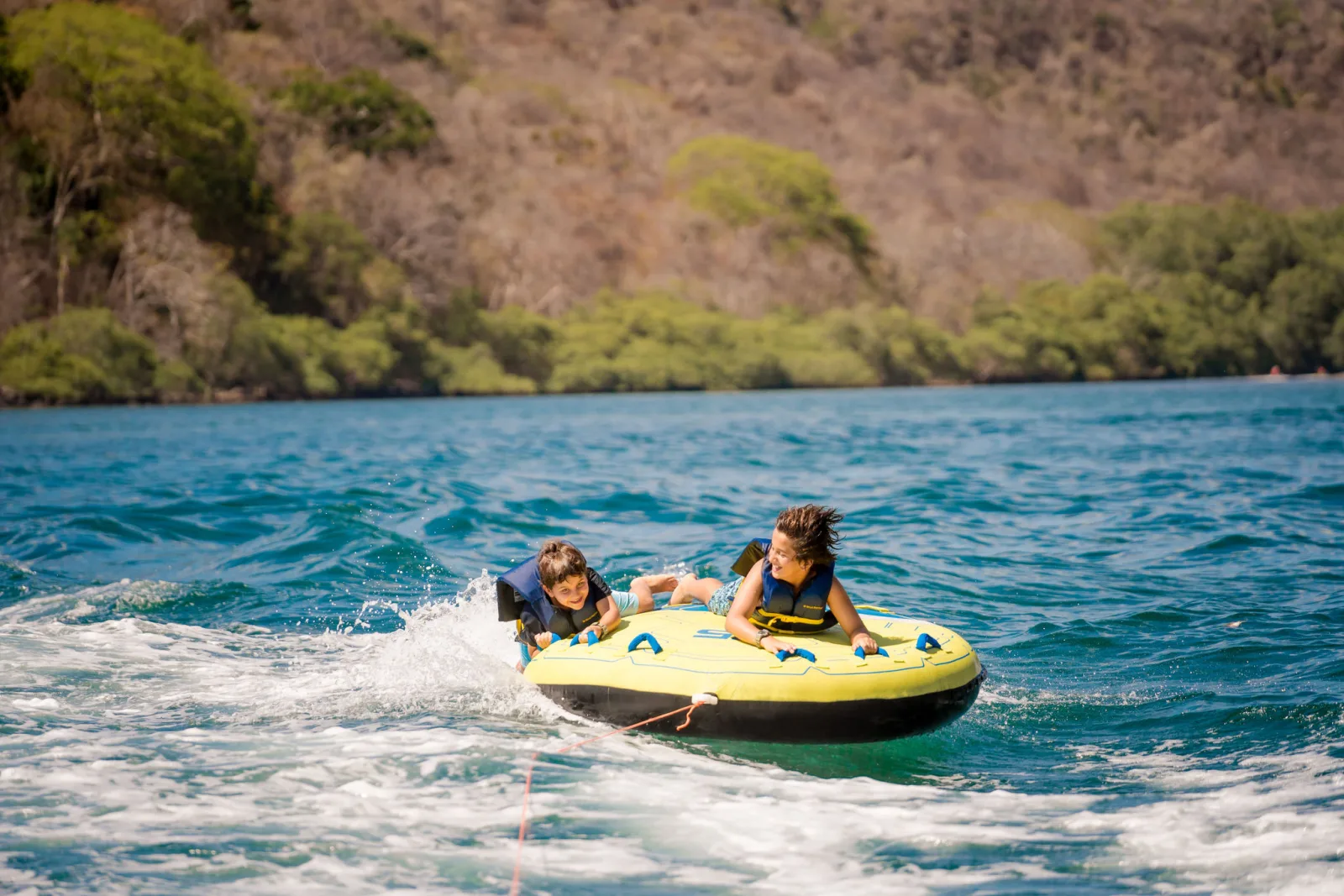 Guests on the towable in the tender's wake
