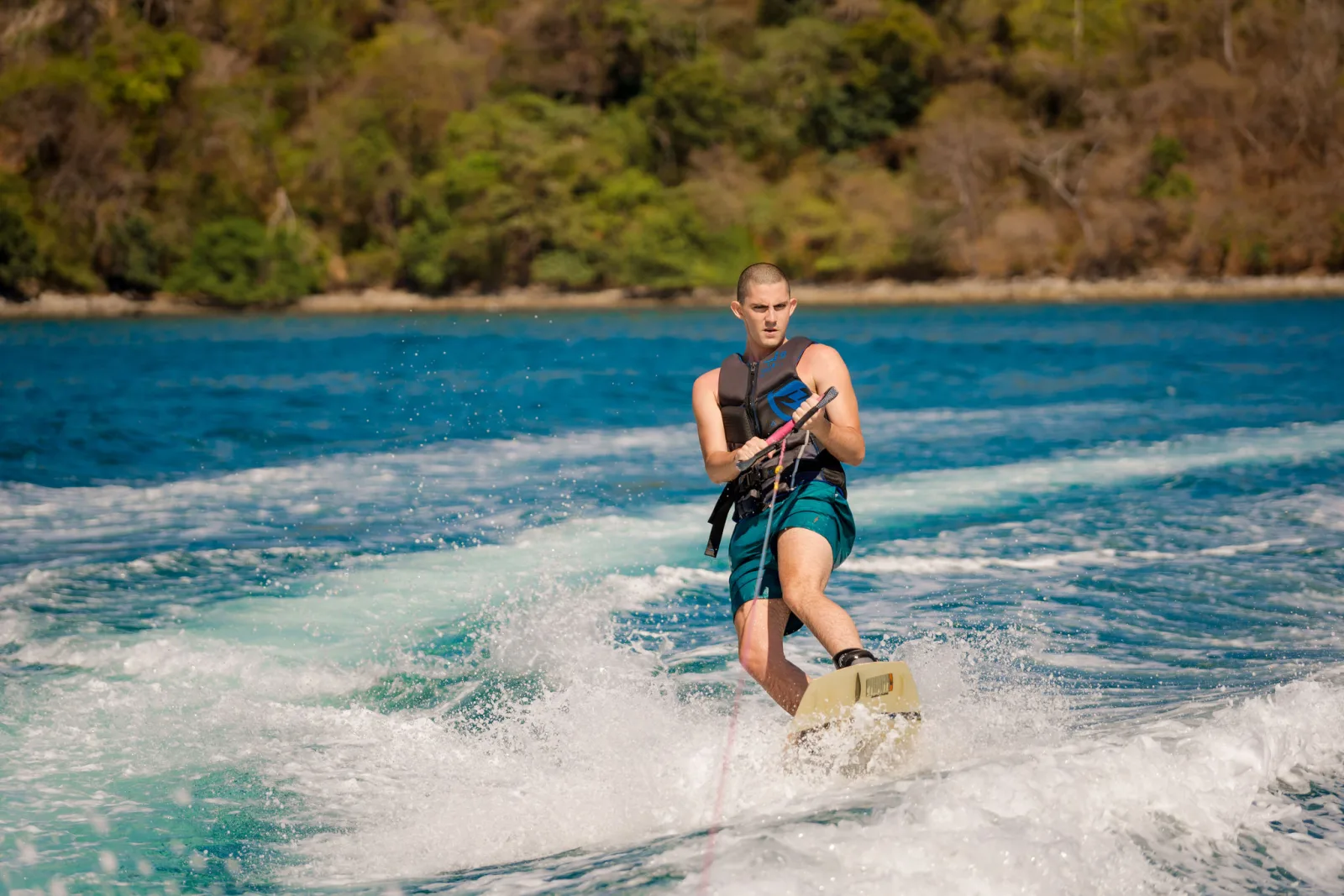 A wakeboarder carving behind the Ocean Club tender