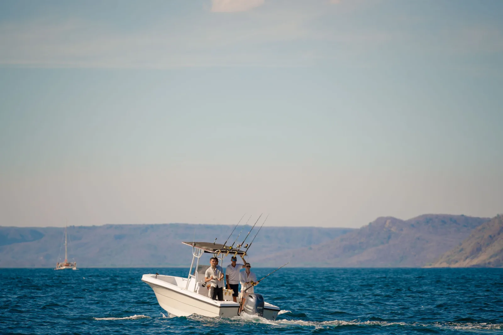 The water-sports tender standing off a quiet stretch of coast