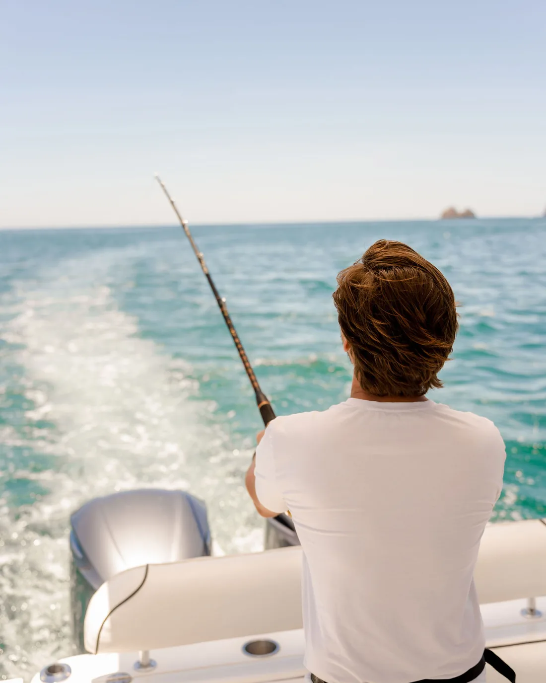 Angler trolling a line from the stern of an Ocean Club boat on Costa Rica's Pacific coast